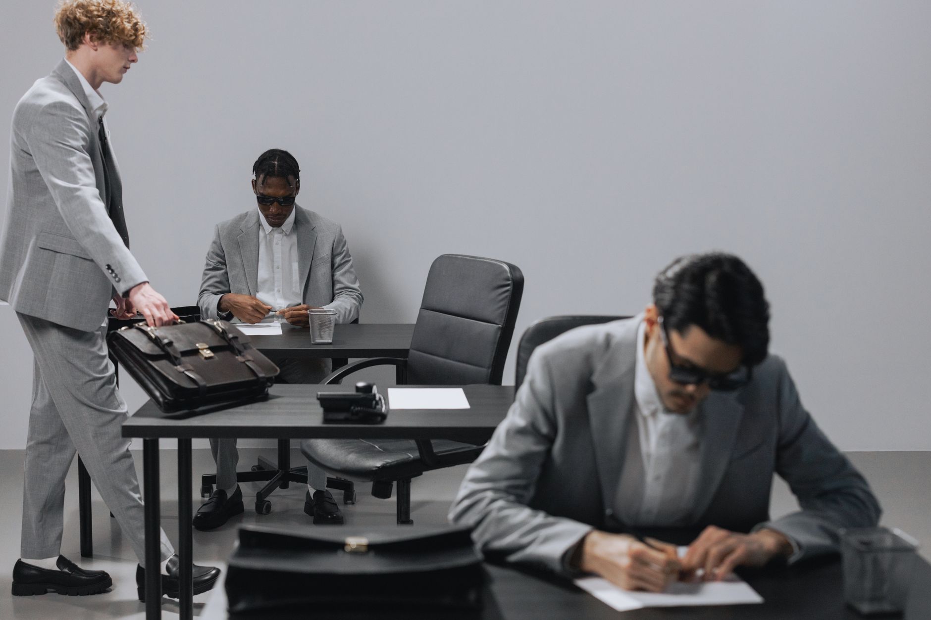 Business office with diverse employees in gray suits working at desks in an indoor setting. — Trade Smarter on MT4: Unlock Po